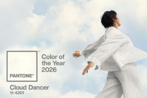 Koloru Roku 2026 wg Pantone - CLOUD DANCER - na tle zdjęcia chmur i ubranej na biało kobiety